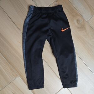 Nike Kids Black Joggers with Orange Swoosh